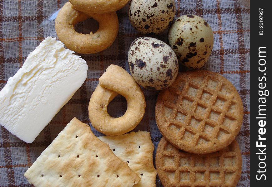 Quail eggs, butter and biscuits on a transparent plate, sitting on a napkin. Quail eggs, butter and biscuits on a transparent plate, sitting on a napkin
