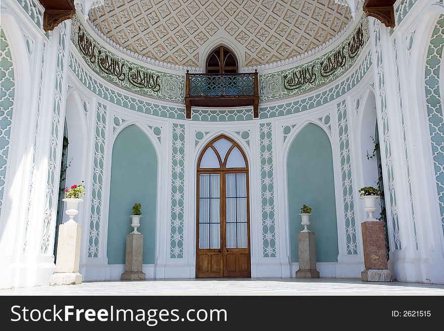 Facade of a palace with a balcony and an arch verandah with a rich ornament in the Italian style of XVI century. Facade of a palace with a balcony and an arch verandah with a rich ornament in the Italian style of XVI century