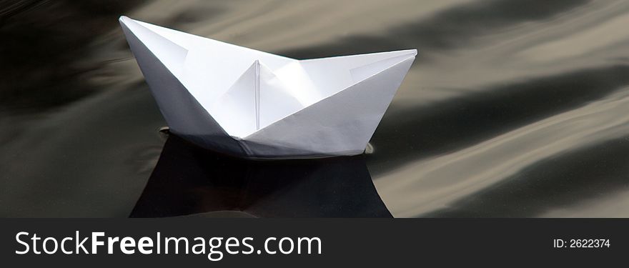 A paper boat navigating across the ocean. A paper boat navigating across the ocean