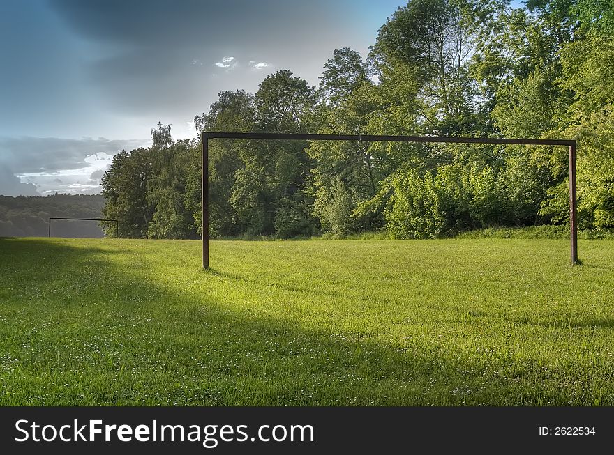 Green landscape with an empty gate