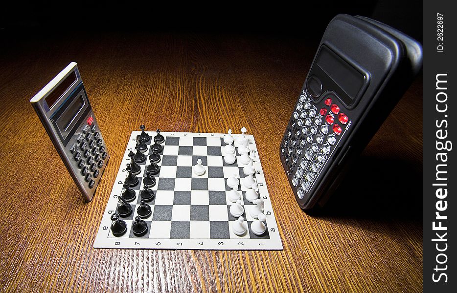 Two calculators, set of chessmen, chessboard, (studio, halogen light). Two calculators, set of chessmen, chessboard, (studio, halogen light).