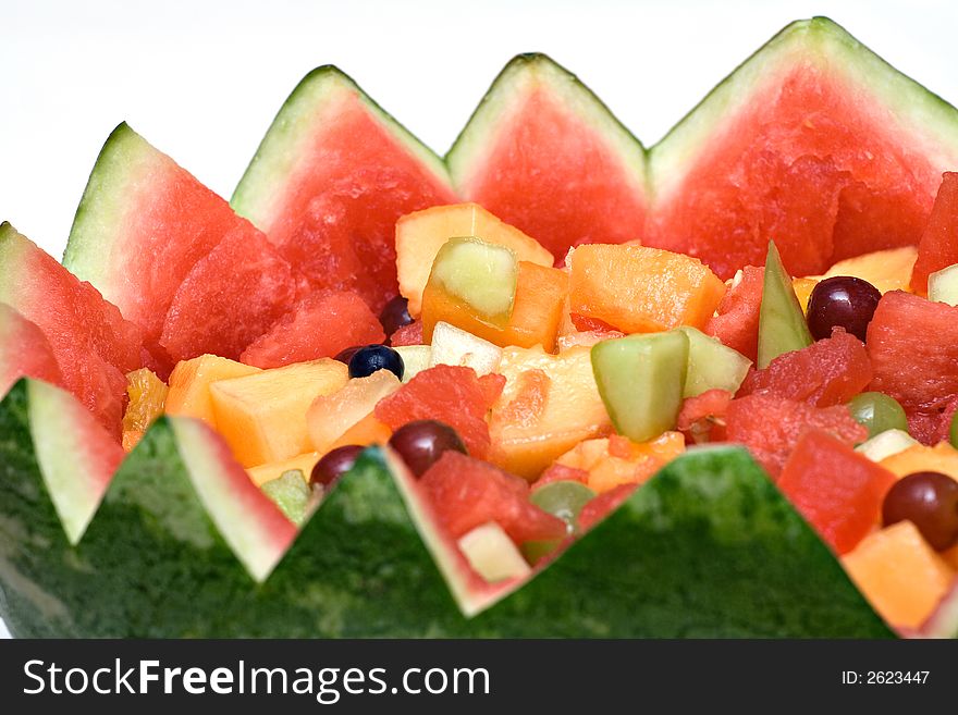 A watermelon carved into a basket filled with fresh fruit. A watermelon carved into a basket filled with fresh fruit.