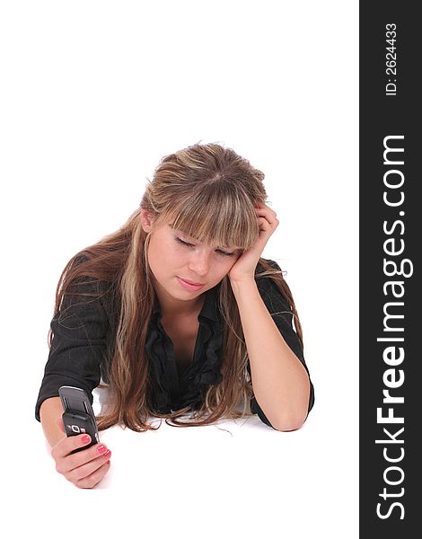 A dissatisfied woman laying with a phone in her hand on white background. A dissatisfied woman laying with a phone in her hand on white background