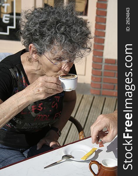 Woman having a espresso coffee in the sun. Woman having a espresso coffee in the sun