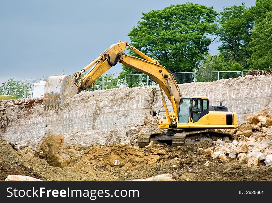 Picture of a backhoe dumping dirt at a construction site