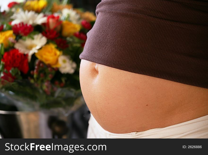 Pregnant woman's tummy with flowers in the background