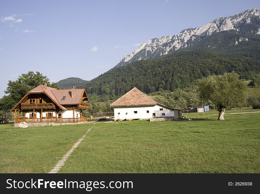 Wooden mountain house in summer time with big garden