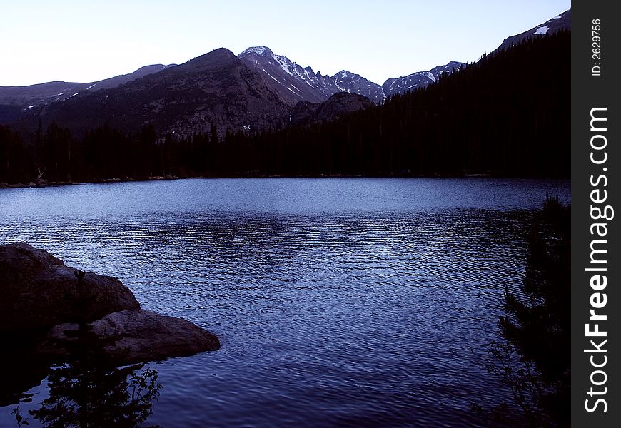 Mountains and lake showing shades of blue at dusk. Mountains and lake showing shades of blue at dusk.