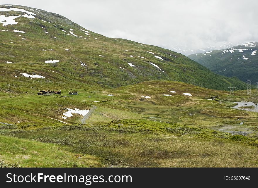 Norwegian landscape with a mountain on background.