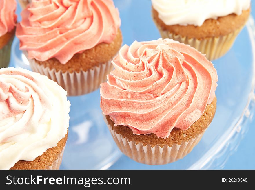 Homemade pink and white cupcakes on the plate. Homemade pink and white cupcakes on the plate