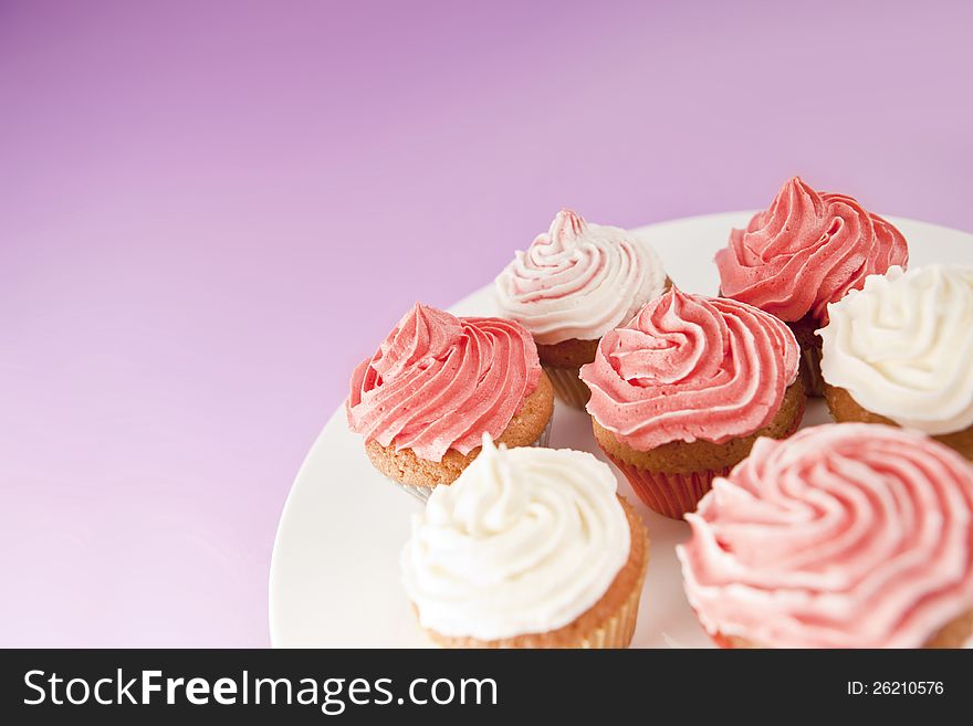 Homemade pink and white cupcakes on the white plate