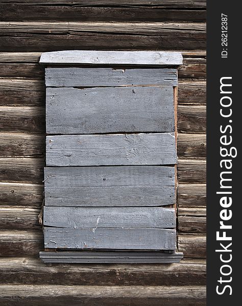 Boarded-up window in a wooden house