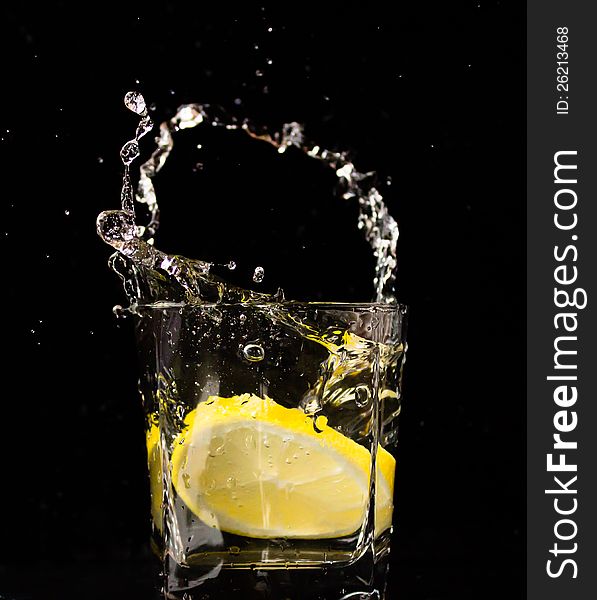 Slice of lemon dropped in a glass of water