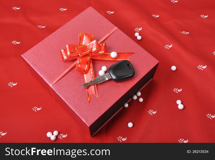 Car keys and gift box on red background