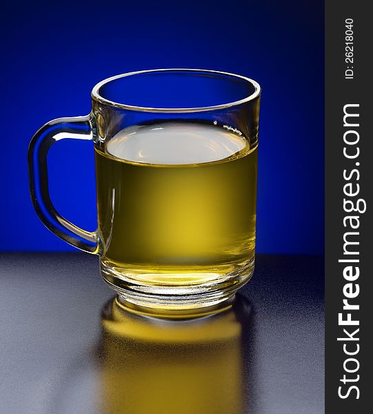 Green tea in a glass cup on a blue background