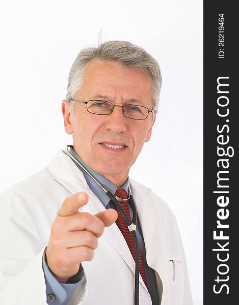 Vertical portrait of  matured, graying doctor with stethoscope on his neck. His eyes attendive but cheerful. He wears a physicianâ€™s white coat, a blue shirt an a red tie. His forefinger indicates the viewer. Vertical portrait of  matured, graying doctor with stethoscope on his neck. His eyes attendive but cheerful. He wears a physicianâ€™s white coat, a blue shirt an a red tie. His forefinger indicates the viewer