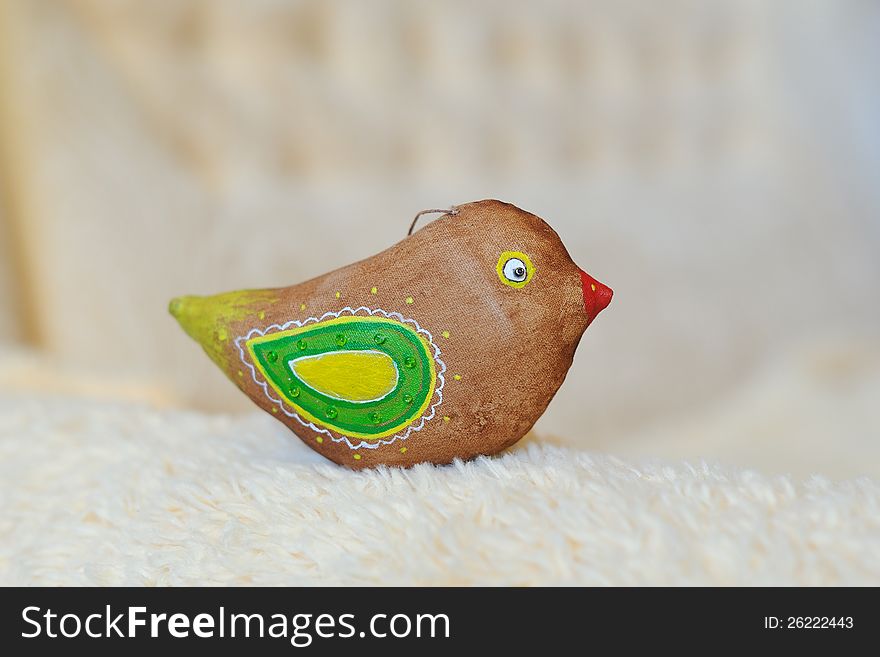 Toy a brown bird of handwork with green wings. Toy a brown bird of handwork with green wings