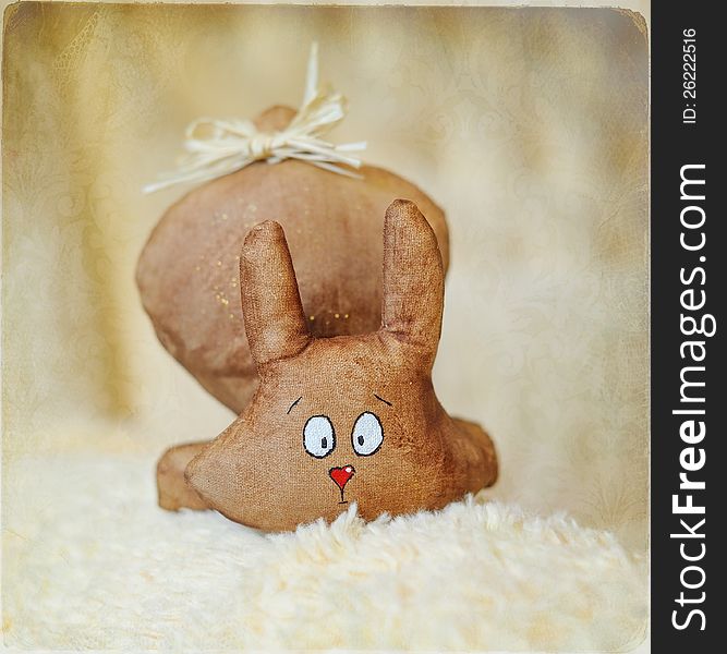 On a light background a toy hare with a wonderful attractive face