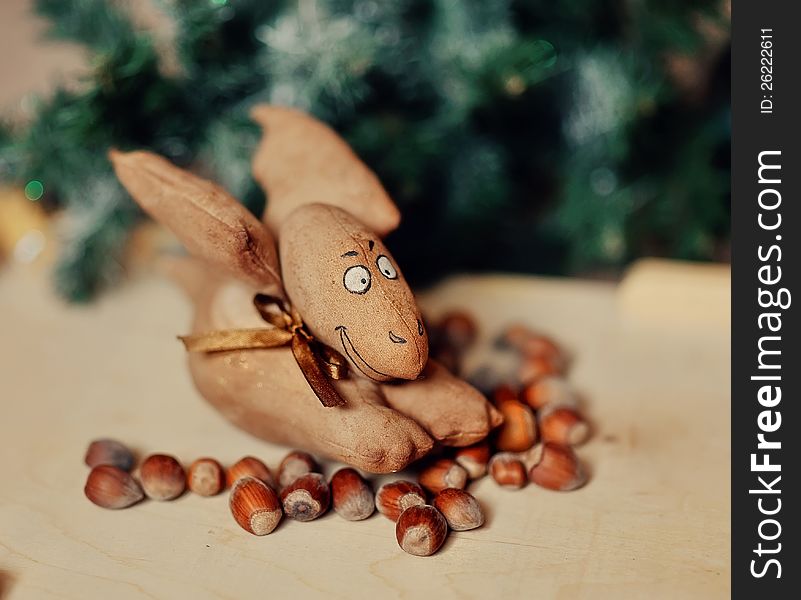 Under a green fir-tree on nuts the wonderful brown toy sits. Under a green fir-tree on nuts the wonderful brown toy sits