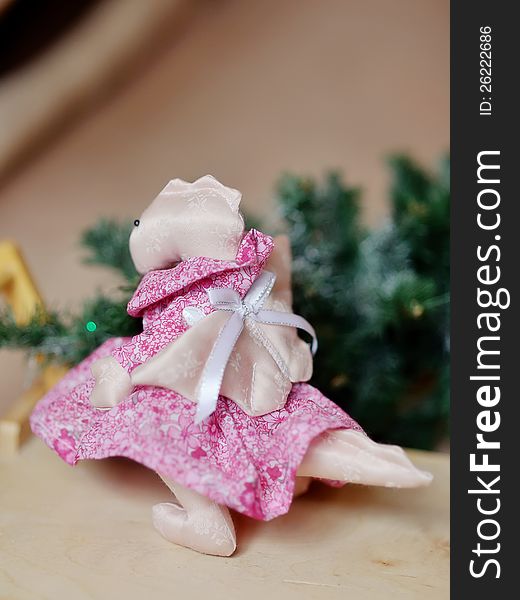 Toy a dragon the girl in a pink dress under a fir-tree. Toy a dragon the girl in a pink dress under a fir-tree