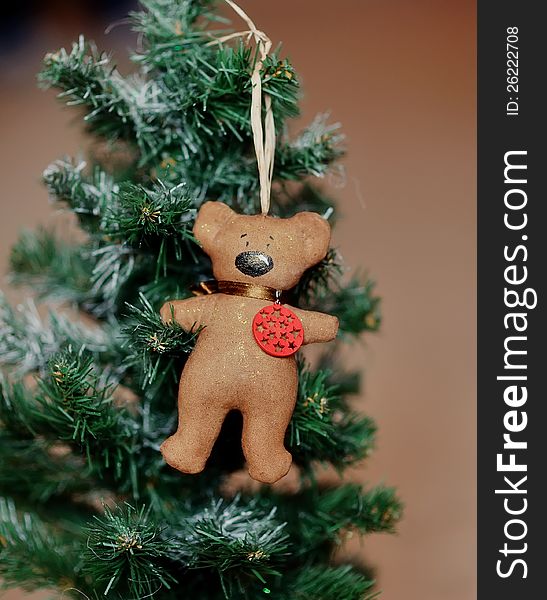 On a green fir-tree the brown bear hangs. On a green fir-tree the brown bear hangs