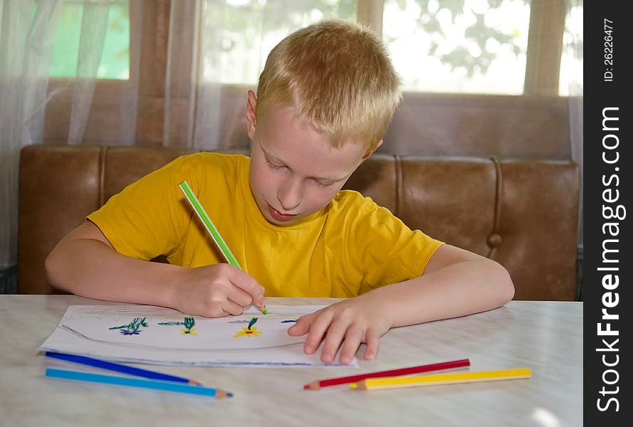 Young boy drawing positive picture with pencils
