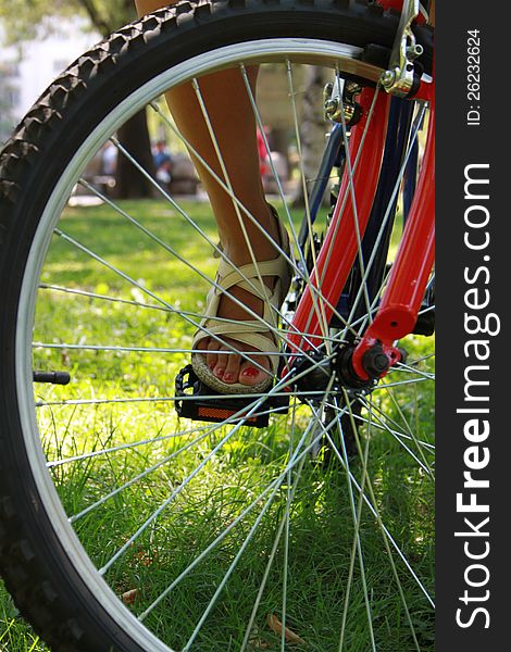 Close-up picture of a bicycle with a woman's foot, detail. Close-up picture of a bicycle with a woman's foot, detail