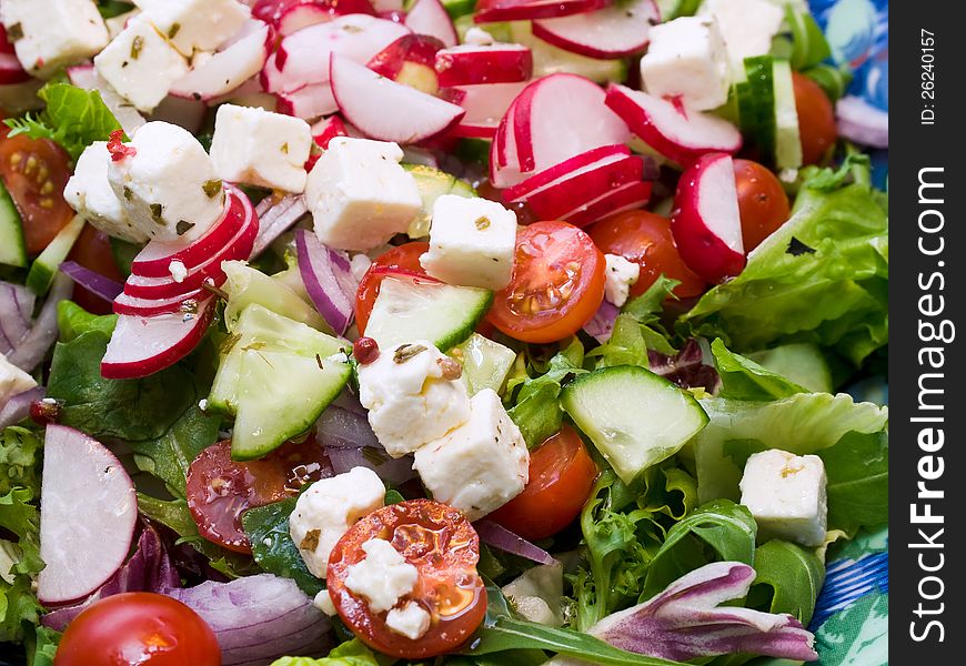 Fresh summer salad with feta cheese, cucumber, cherry tomatoes and radishes.