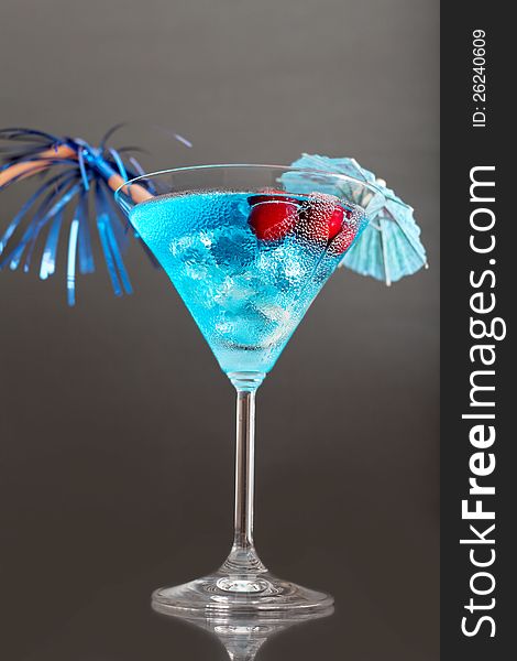 Blue cocktail with ice and umbrella