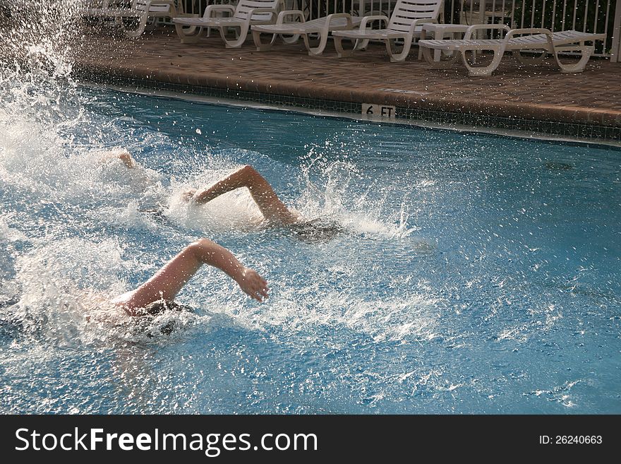 Swimmers racing to the finish line. Arms in the air, lots of splashing water. Swimmers racing to the finish line. Arms in the air, lots of splashing water