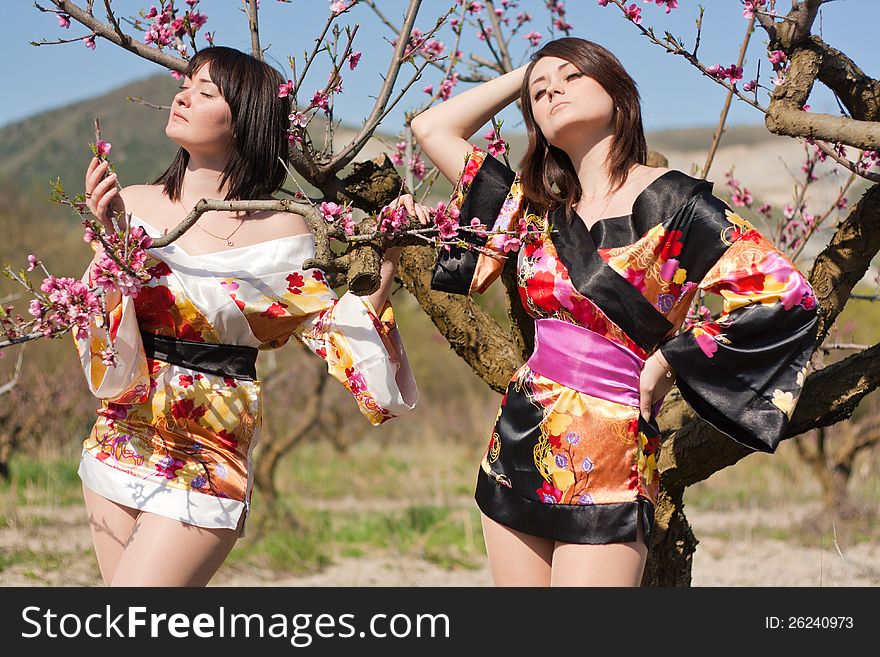 Girls in kimono and flowerses of the peach. Girls in kimono and flowerses of the peach