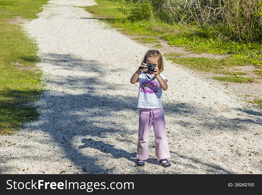 Young girl on a gravel path taking a picture facing the photographer. Young girl on a gravel path taking a picture facing the photographer.