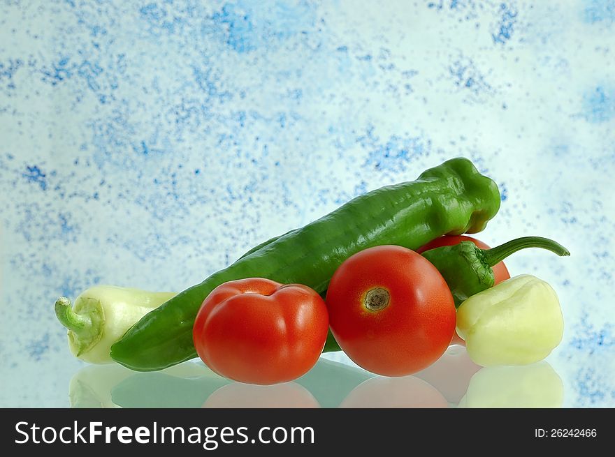 Tomatoes and peppers with a colored background