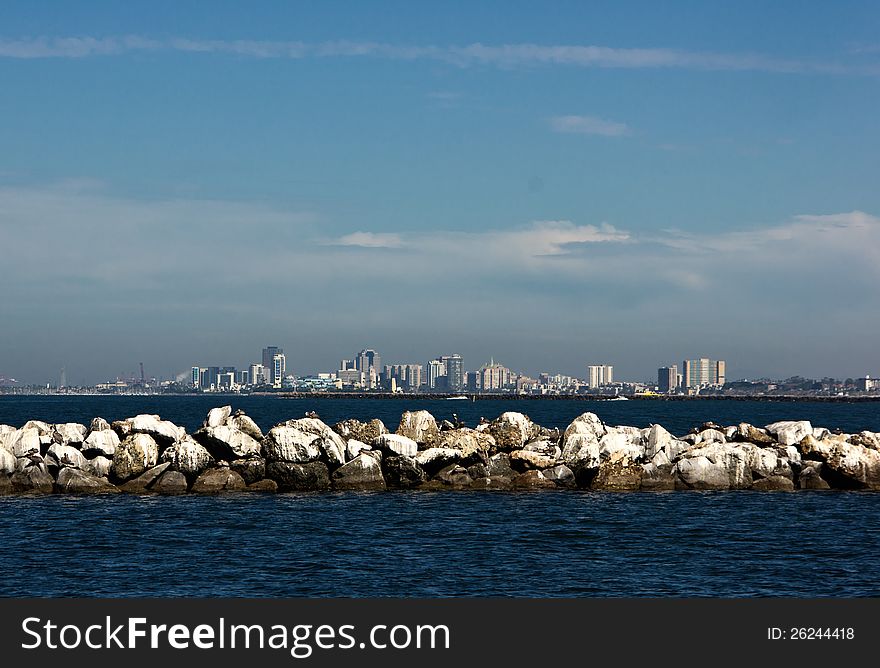 Rock jetty with cityscape of Long Beach in the background. Rock jetty with cityscape of Long Beach in the background