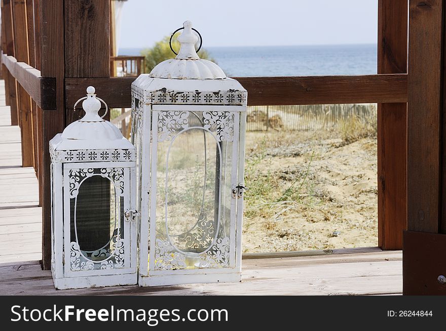 Candle lantern on a wooden deck  at the beach, Algarve, Portugal. Candle lantern on a wooden deck  at the beach, Algarve, Portugal..