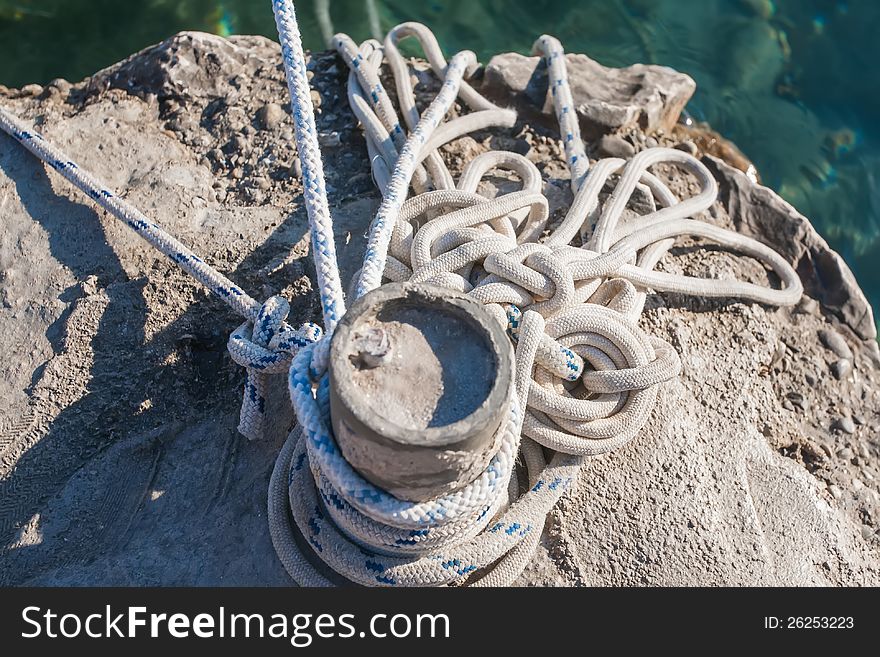 The rope is tied to shore around the pole. The rope is tied to shore around the pole.