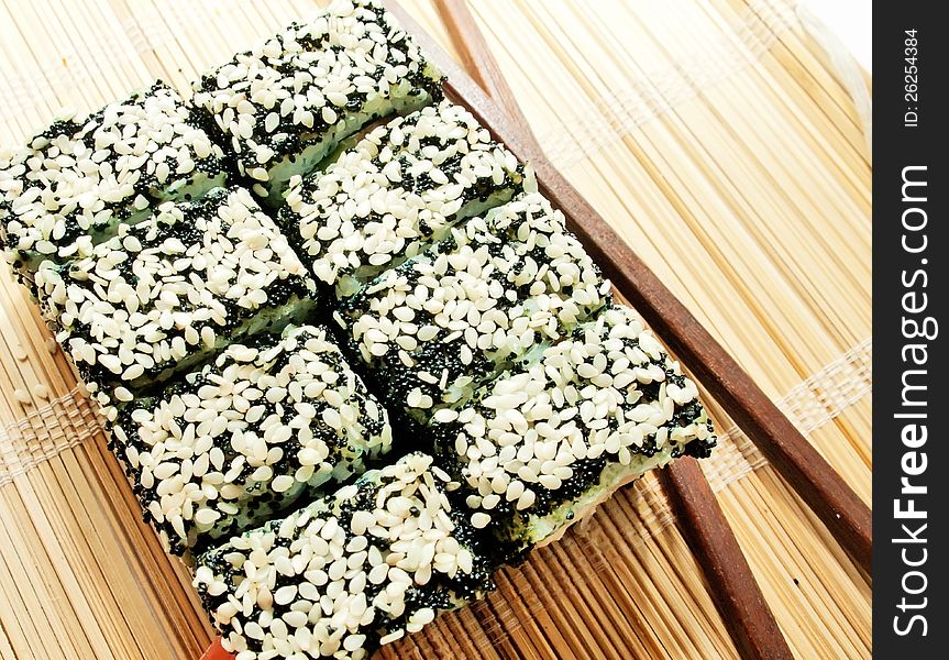 Sushi rolls with black roe and sesame on bamboo mat