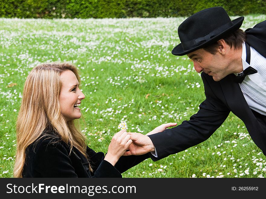 A men offering daisies to a beautiful young girl. A men offering daisies to a beautiful young girl.