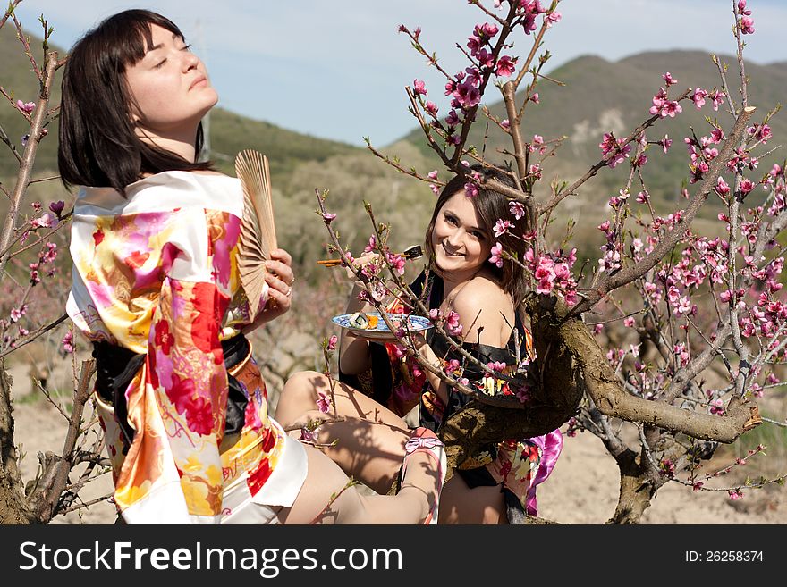 Girls in kimono and flowerses of the peach. Girls in kimono and flowerses of the peach
