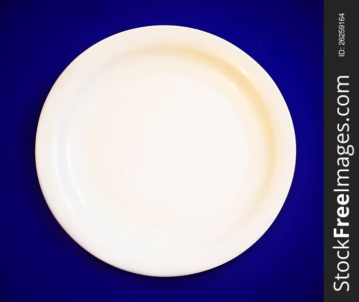 An empty plate on blue background. An empty plate on blue background.