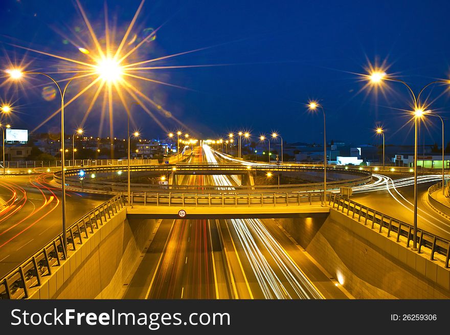 Trails of passing cars on and under roundabout. Trails of passing cars on and under roundabout