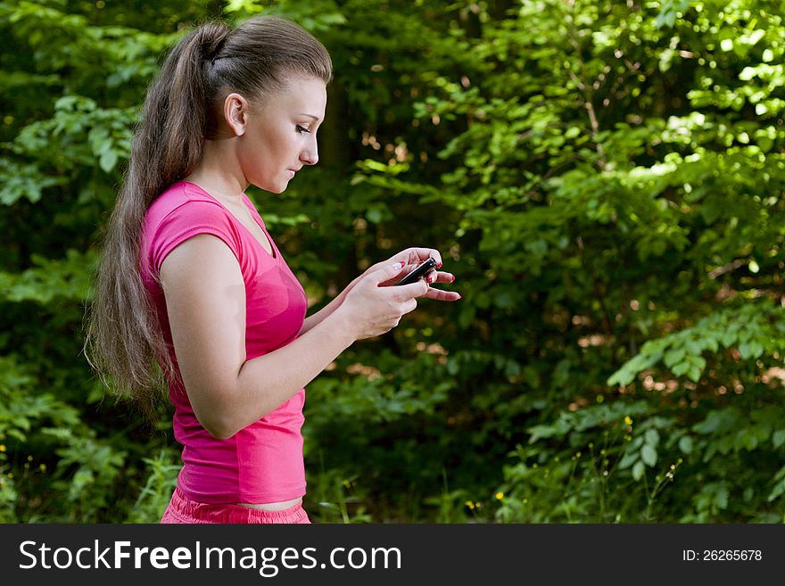 Beautiful girl with the phone walking forest. Beautiful girl with the phone walking forest