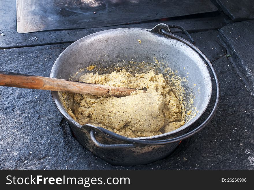 Cooking the traditional polenta of Valtellina mountains, on wood stove. Cooking the traditional polenta of Valtellina mountains, on wood stove