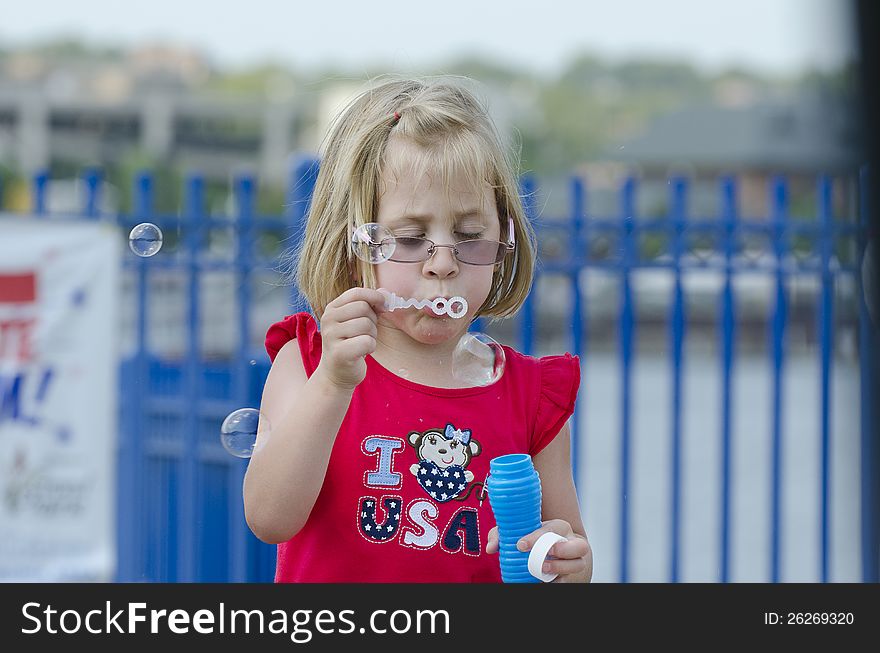 Girl blowing bubbles in the wind