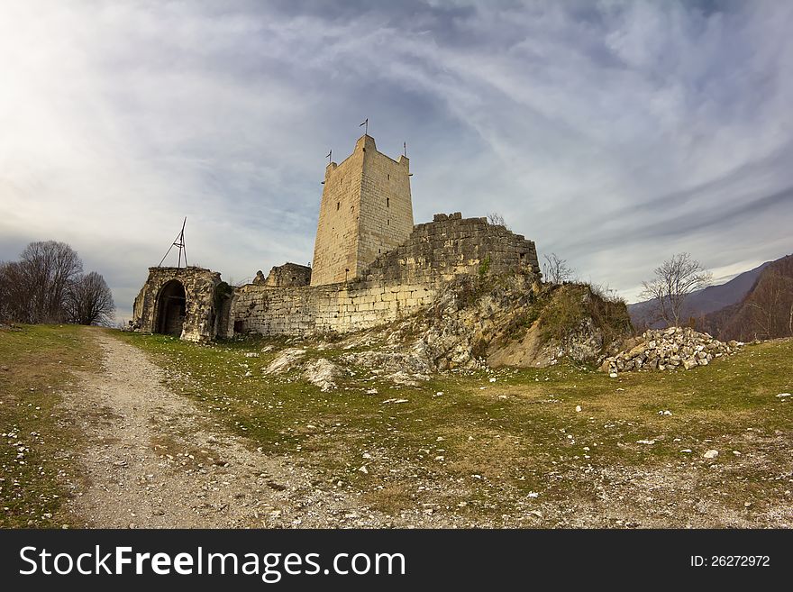 Ancient fortifications in the mountains in the rays of sunset. Genoese fortress