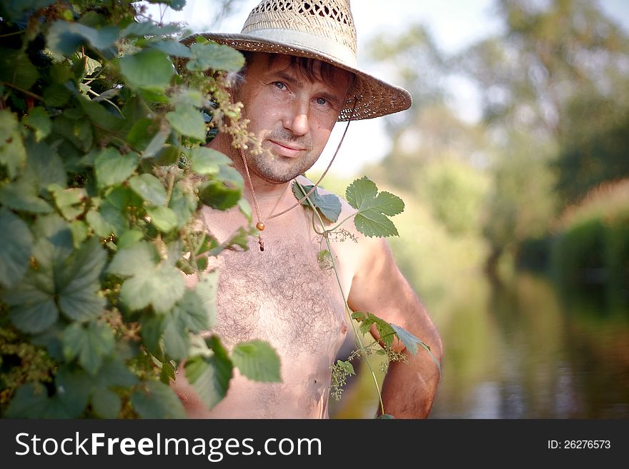 The man in a straw hat has a rest outdoors