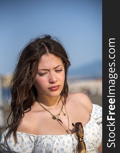Upper body portrait of thoughtful teenage girl outdoors in city of Naples, Italy.