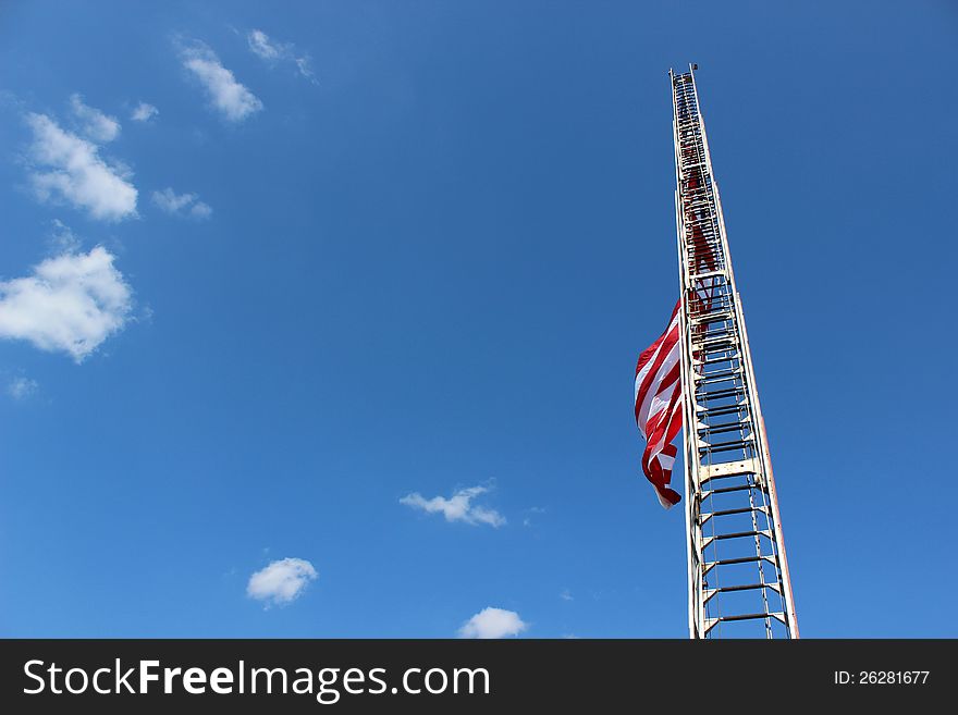 Fireman's ladder open to it's full height with the American flag flying from it's rungs. Fireman's ladder open to it's full height with the American flag flying from it's rungs.