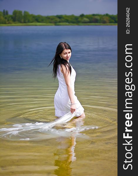 A beautiful brunette posing at a calm lake. A beautiful brunette posing at a calm lake