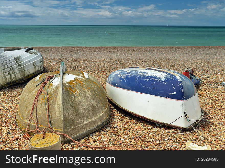 Three boats on the beach upside-down